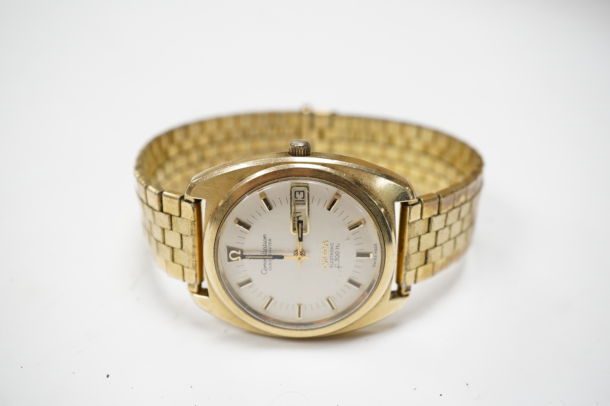 A gentleman's steel and gold plated Omega Constellation Electronic wrist watch, with baton numerals and day/date aperture, case diameter 38mm, on an associated gold plated strap. Condition - poor